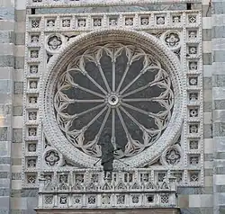 La rosace sur la façade et la statue de St Jean Baptiste.