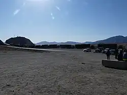 Des camions attendent à la frontière chinoise. La route est asphaltée.