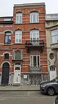 Au no&nbsp;9 : maison éclectique de composition asymétrique, 1912, architecte Fernand Conard. Façade de briques rouges, rehaussée d'éléments de pierre bleue et rythmée d'assises de briques blanches.