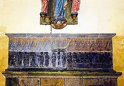 Photo montrant un retable de pierre fixé sur un mur.