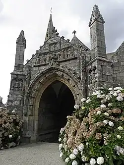 Photographie d'un porche d'église en granite, sculpté en bas-relief