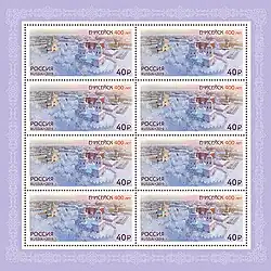 Feuille de 8 timbres représentant une ville enneigée avec deux édifices religieux orthodoxes.