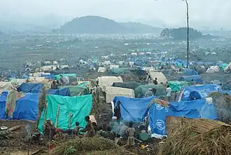 Photographie couleur montrant un camp de tentes sur une grande étendue.