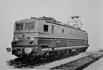 L'image noir et blanc montre une locomotive électrique avec des jupes qui couvrent bogies et bas de caisse.