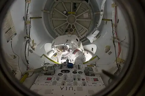 Alvin Drew entame une sortie extravéhiculaire en quittant le sas par son écoutille extérieure.