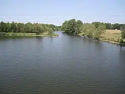 Vue d'un cours d'eau formant un goulot d'étranglement bordé d'arbres.