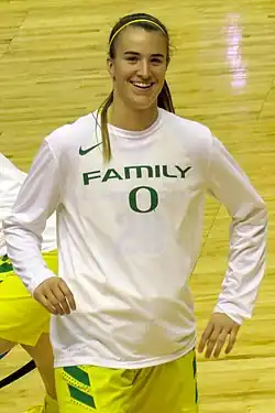 Une joueuse de basket-ball en survêtement d'entraînement, souriante.