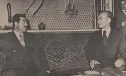 Deux hommes en costume en discussion.