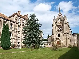 Photo d'un bâtiment imposant de plusieurs étages et d'une chapelle.