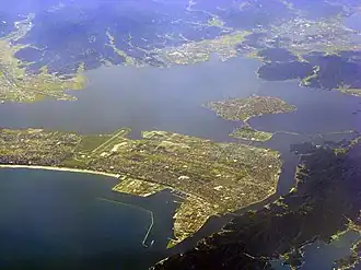 Vue aérienne couleur d'un port maritime, s'étendant entre deux étendues d'eau.