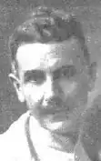 Photographie ancienne en noir et blanc d'un homme moustachu.