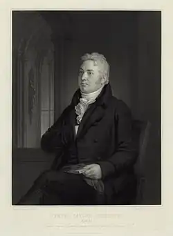 Un homme aux cheveux blancs et habillé en noir.