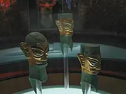 Masques, bronze revêtu de feuille d'or, période Shang mais hors de son territoire. h : 42&nbsp;cm env. Vers 1200. Musée de Sanxingdui, Sichuan.