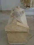 Vue d'une sarcophage dont le couvercle représente un personnage féminin.
