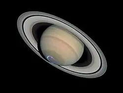 Vue éloignée de Saturne. Un cercle bleu est visible au pôle sud.