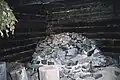 Poêle de sauna à fumée (Musée de la forêt lapone à Rovaniemi). Il s'agit d'une reconstitution d'un sauna de forestiers tels qu'on en trouvait en Laponie. Dans une installation moderne, il serait prudent d'isoler le mur en rondins de la chaleur du poêle.