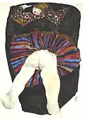 Portrait en plongée d'une fille à plat ventre sur un tissu noir, bras à la tête, jupe multicolore relevée sur les fesses nues, vulve soulignée de rouge