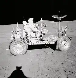 Photographie en couleur de Scott conduisant le rover lunaire.