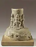 Socle d'un "arbre à sapèques" avec le Buddha assis. Dynastie des Han de l'Est, IIe&nbsp;siècle. Mis au jour au Sichuan. Céramique à glaçure brunâtre. H. 21,3 cm. Musée de Nankin