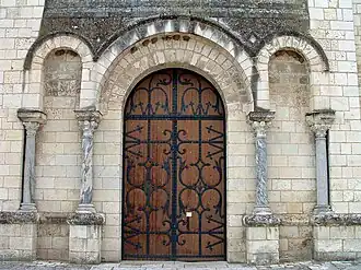 Le portail avec des colonnes et des chapiteaux pouvant provenir de la basilique mérovingienne.