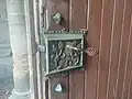 Poignée en fer forgé sur un serrure en bronze ouvragé, église Notre Dame des Vertus, Ligny-en-Barrois, Meuse, France.