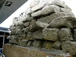 Photographie en couleurs d'un mur composé d'un empilement de gros blocs.