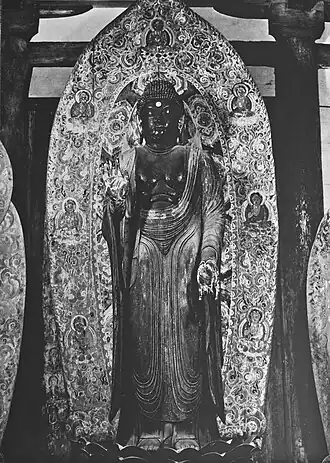 Yakushi Nyorai, dit Shaka Nyorai debout. Fin IXe siècle. Bois peint, H. 2,38 m. Murō-ji, Nara.