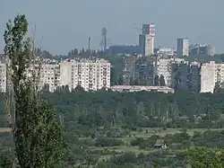 Mine au loin, derrière des immeubles d'habitation et des espaces verts