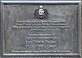 Plaque grise rectangulaire indiquant : «&nbsp;Près de cette localité le 16 décembre 1910 trois policiers de la "City of London Police" ont été tués en empêchant un cambriolage au numéro 199 Houndsditch. En souvenir des Sgt Robert Bentley, Sgt Charles Tucker, PC Walter C. Choat, que leur bravoure et leur sens de la fonction ne soient pas oubliés ».