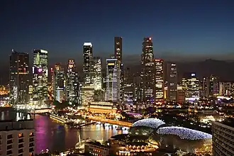 Grattes-ciel de nuit avec la rivière Singapour au pied des immeubles.
