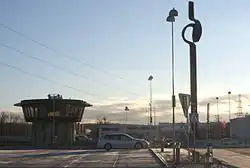 Un parking, avec la "tour de contrôle" et la sculpture d'Aston Forsberg, Vridande moment.