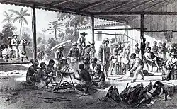 Gravure représentant une large étable sans murs avec des hommes torses nus rassemblés autour d'un chaudron au premier plan. D'autres personnages sont engagés dans diverses activités à l'arrière-plan et des cavaliers entrent dans le bâtiment sur la gauche de l'image.