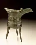 Vase jue pour chauffer l'alcool, à décor en forme de masque. Bronze et pierres dures. Période d'Erligang. Musée d'art du comté de Los Angeles LACMA