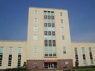 Vue partielle de la façade d'un bâtiment de deux étages. Au milieu, une partie plus élevée.