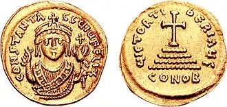 Photographie des deux faces d'une pièce de monnaie en or, une face représentant un buste d'empereur et l'autre une croix.