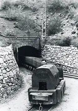 Une locomotive tirant ses berlines en sortant de la mine