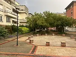 Photographie d'une place urbaine arborée.