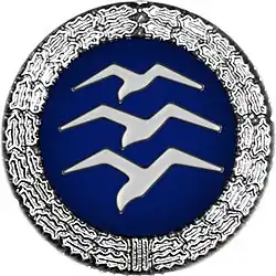 Insigne: Disque bleu entouré d'une couronne d'argent avec 3 mouettes empilées en vol Insigne d'argent