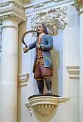 E. La statue, datant du XVIIIe&nbsp;siècle, atteste que l'on portait encore en Bretagne la mode de cent ans auparavant.