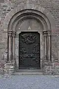 Chapiteau roman à l'Homme vert du portail sud (vers 1150) et bas-reliefs en bronze de Valdemar Grzimek (1972 et 1976)