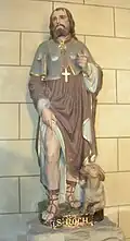 Statue de saint Roch montrant sa plaie