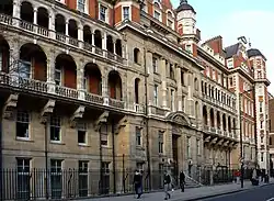 Facade d'un immeuble de cinq étages vue de puis le trottoir situé de l'autre côté de la rue