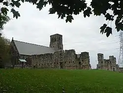 église flanquée à droite de murs en ruine