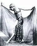 ¨Photo noir et blanc d'une femme de profil en costume oriental, écartant un grand voile de ses mains