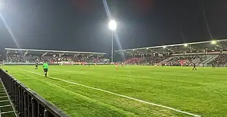 Photographie prise au niveau du terrain d'un stade de football.