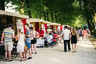 Photo d'une allée des stands des exposants lors de la quatrième édition du Brussels Games Festival au Parc du Cinquantenaire où des maisons d'édition présentaient des jeux, des boutiques en vendaient et des associations faisaient de la sensibilisation en utilisant le jeu comme outil