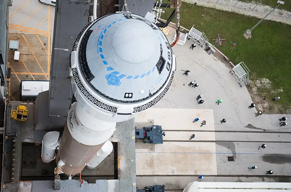 Une vue plongeante du véhicule CST-100 fixé au sommet de son lanceur Atlas V.