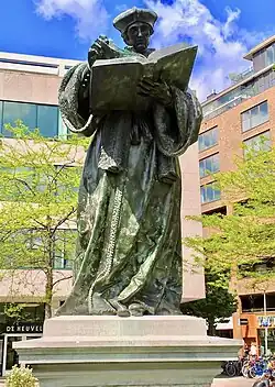 statue d'un homme en robe tenant un livre à deux mains