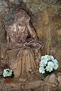 Statue de la Madeleine, au fond d'une grotte artificielle. Notez le crâne sous le crucifix qu'elle tient en main.