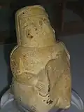 Idole de couleur ocre avec un morceau brisé qui devait être un enfant.